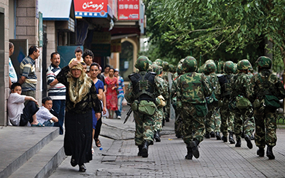 Chinese soldiers patrol the streets of a Uyghur neighbourhood