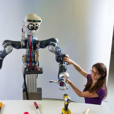 Forscherin justiert Roboter