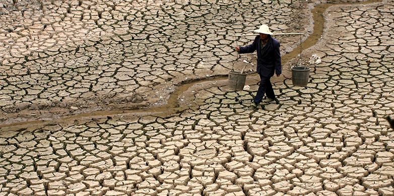 Vergrösserte Ansicht: Ein chinesischer Bauer sucht Wasser in einem ausgetrockneten Flussbett.