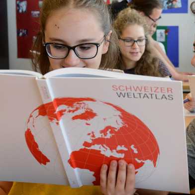 Schüler blättern im Schweizer Weltatlas