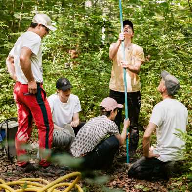 Fünf Studierende im Wald bei der Arbeit