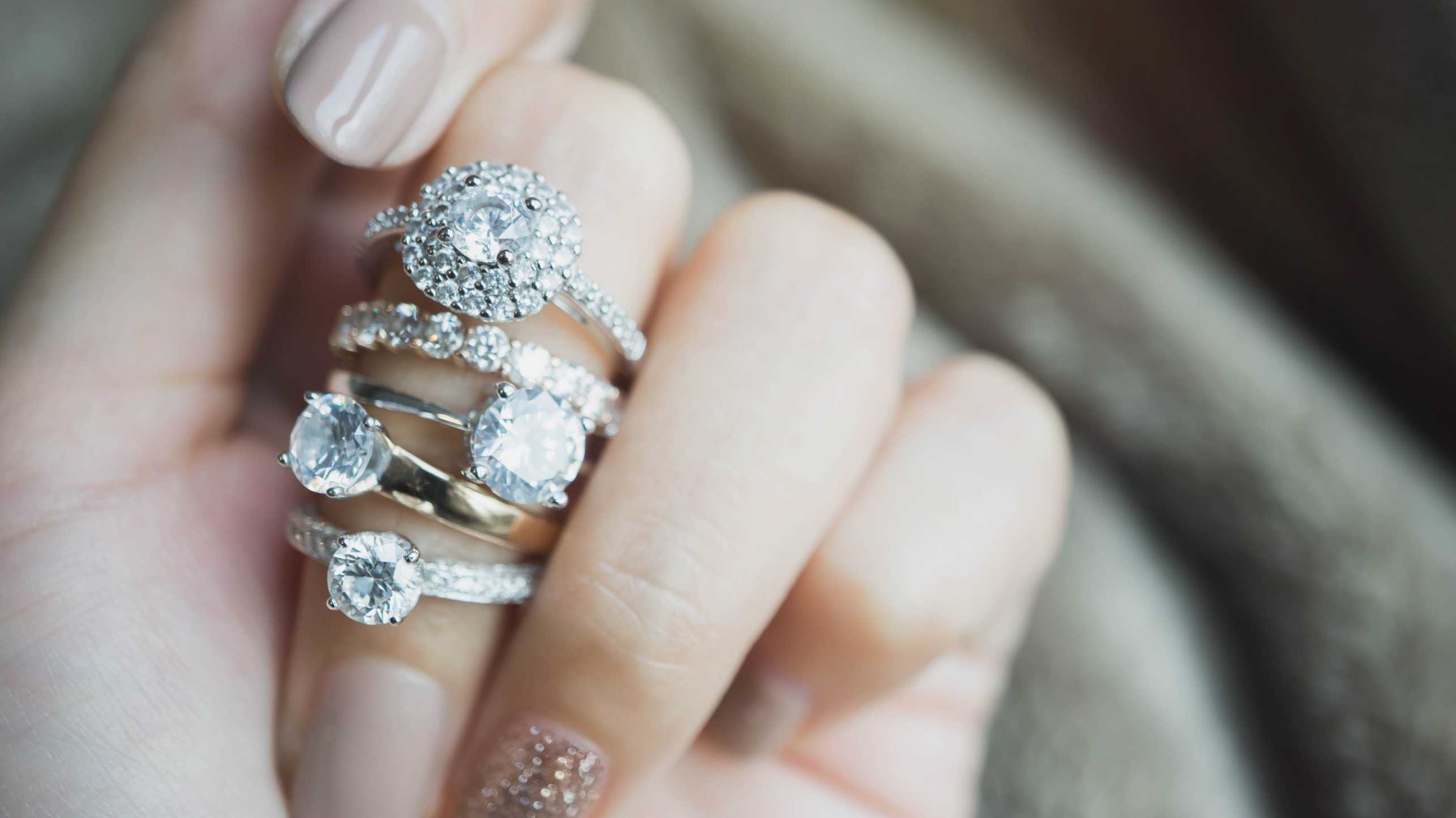 Vergrösserte Ansicht: Eine Frauenhand mit vielen Diamantringen