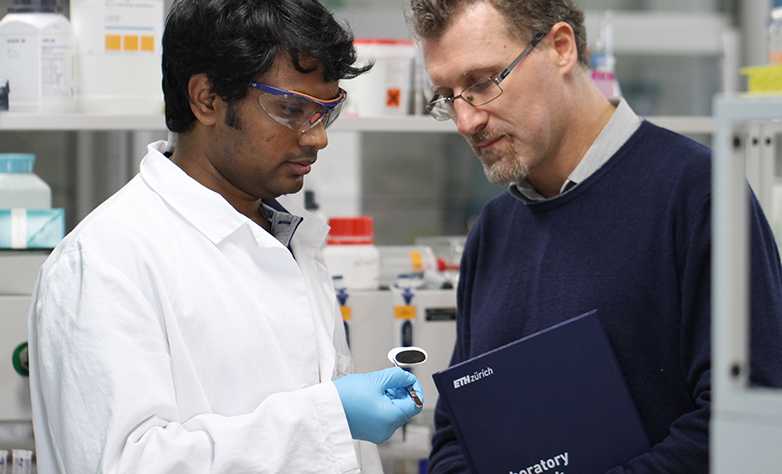 Enlarged view: Raffaele Mezzenga (right) and Sreenath Bolisetty examine a sample of their novel filter membrane in the laboratory. (Photograph: ETH Zurich)