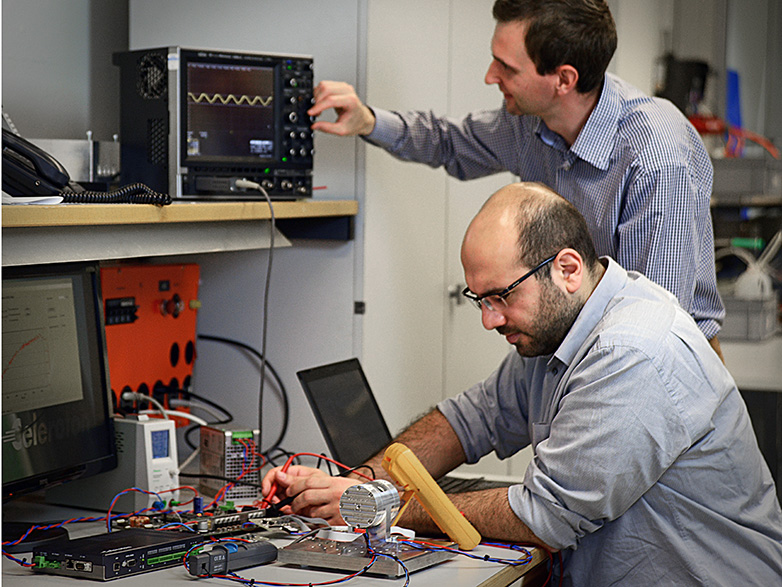 Arda Tüysüz (ETH/PES, in front) and an employee of Celeroton work on the new ultra-fast motor in their laboratory.