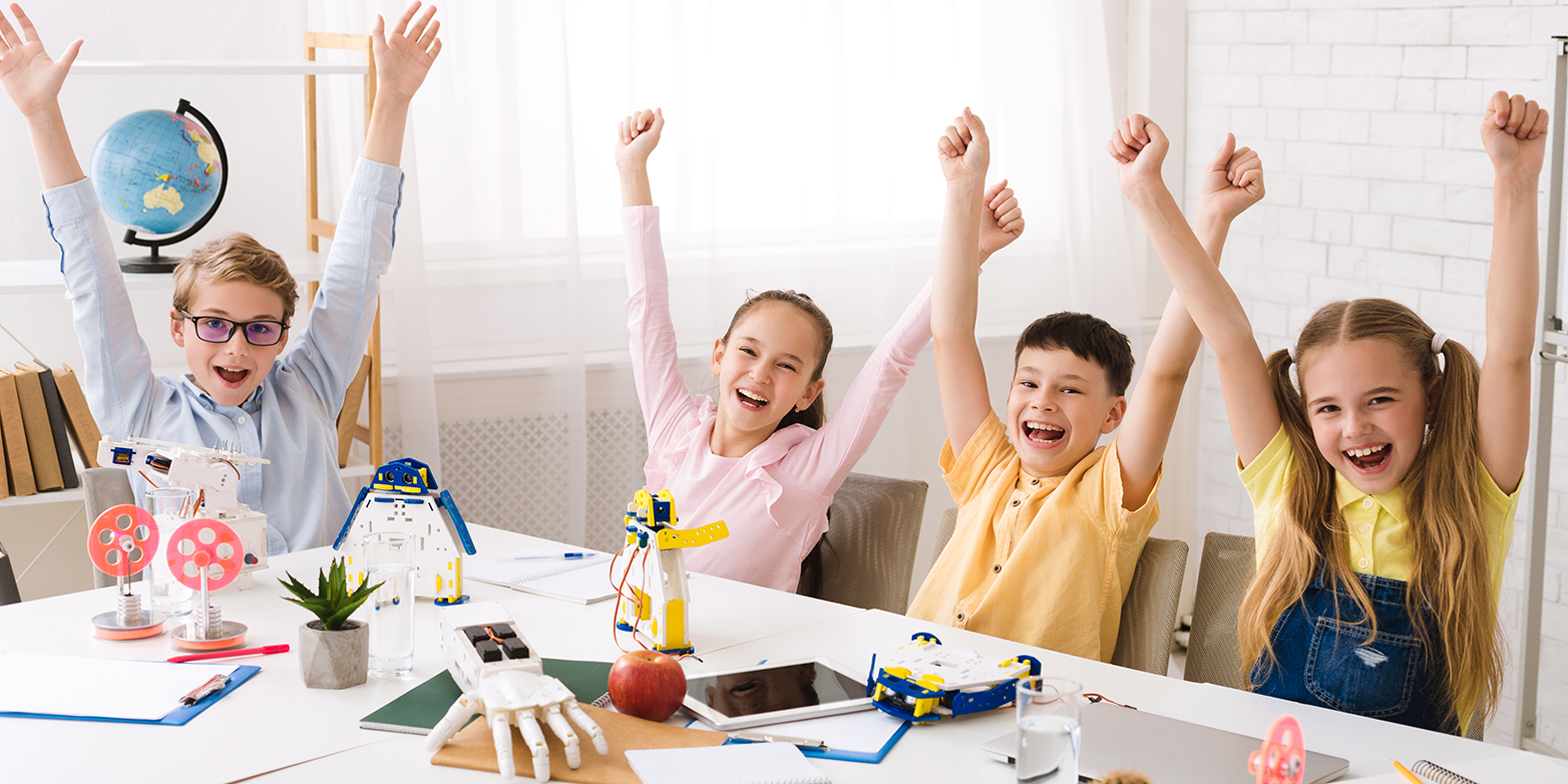 Children cheering sitting at a table