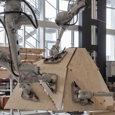 Four hanging robotic arms with wooden boards