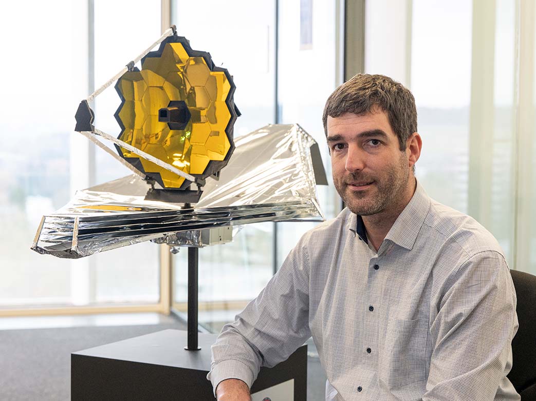Adrian Glauser with a model of the James Webb Space Telescope