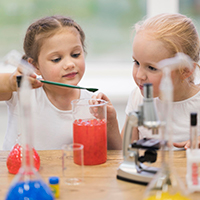 Two young girls experiment with a test tube