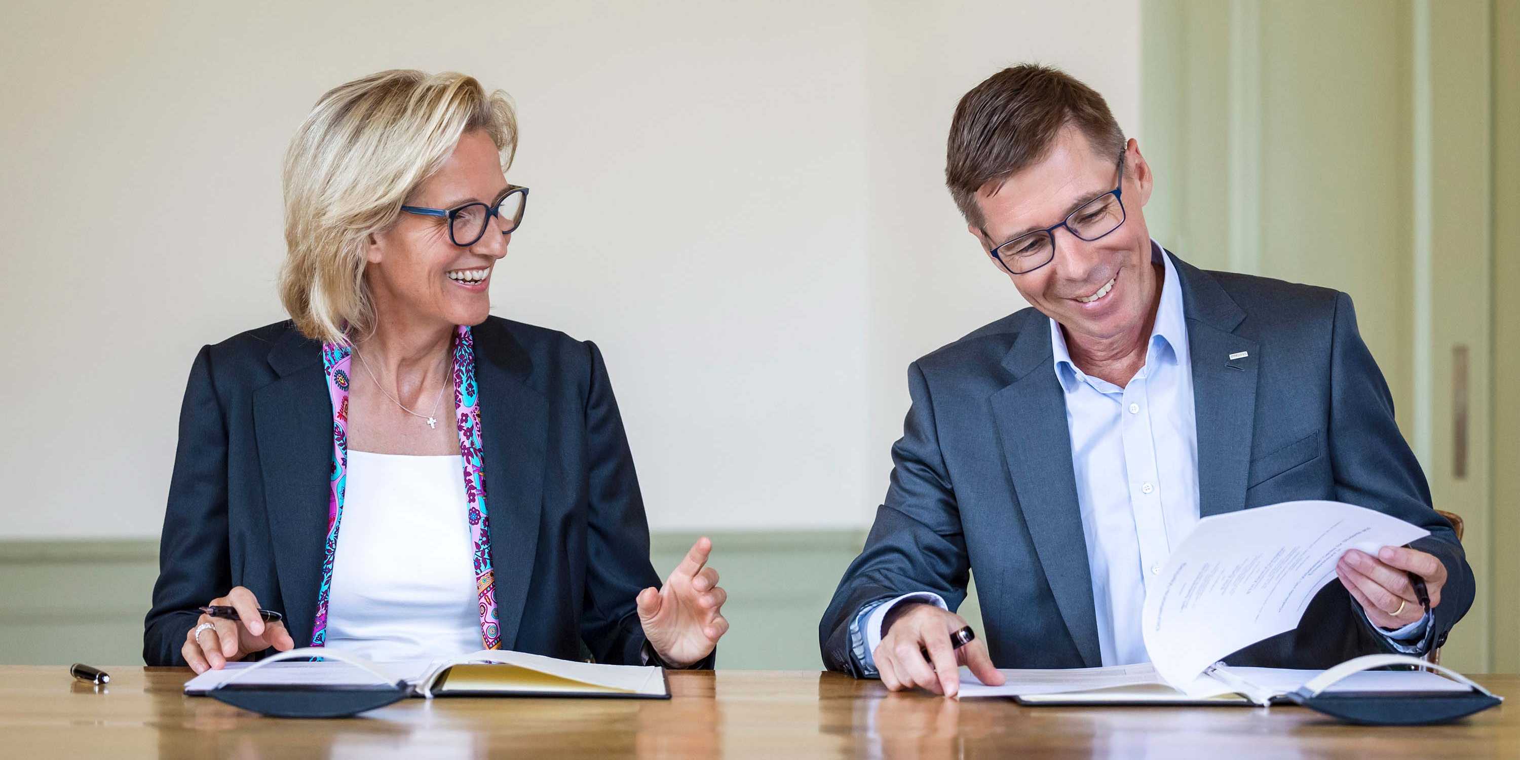 Sabine Keller-Busse and Joël Mesot smilingly sign the contract