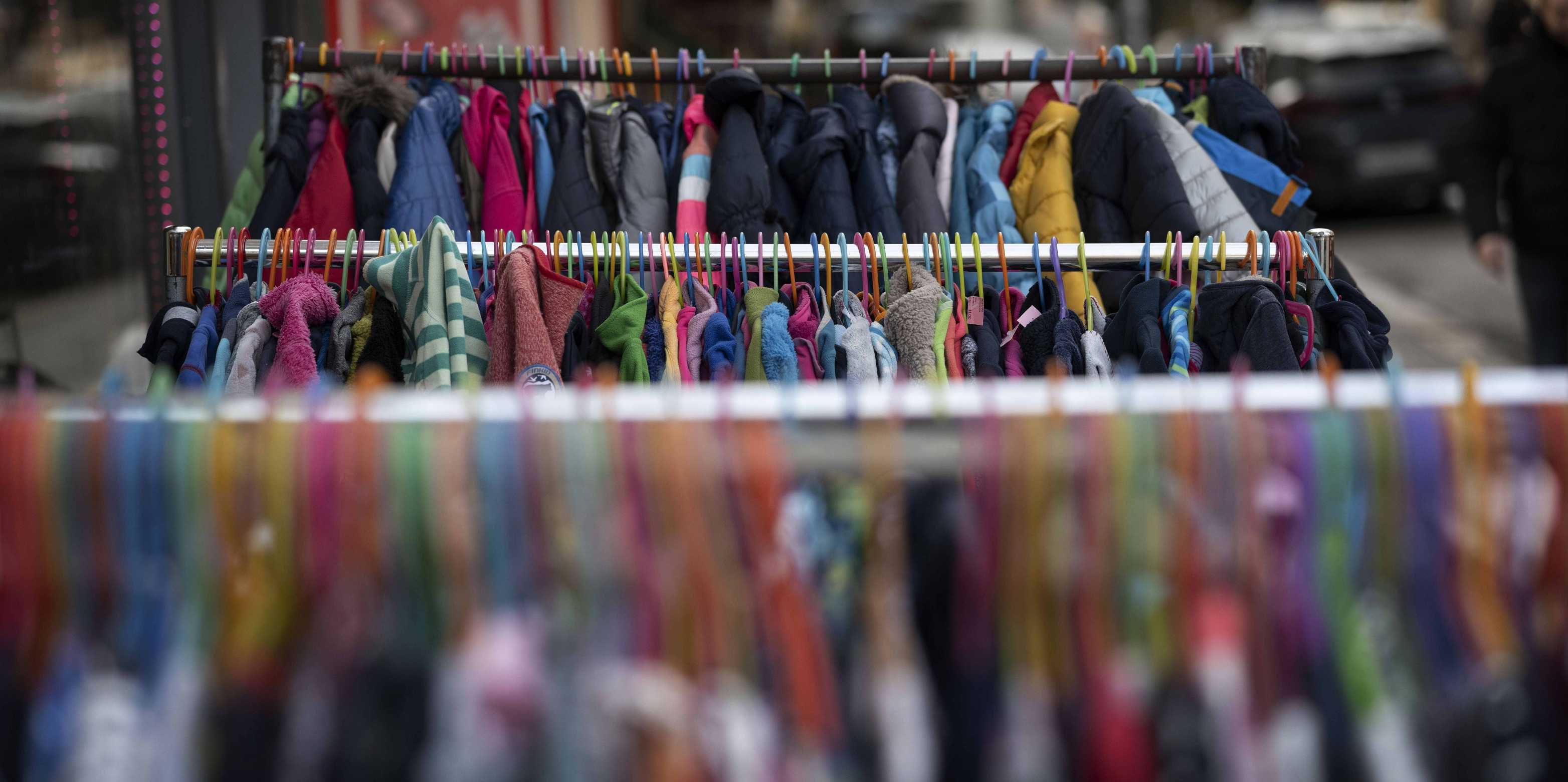 Close-up of clothes racks from a second-hand shop.
