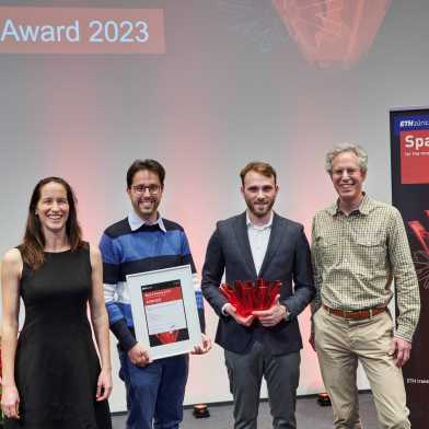 The three winners of the Spark Award 2023 stand to the right of Vanessa Wood. They hold the award and the prize in their hands. 