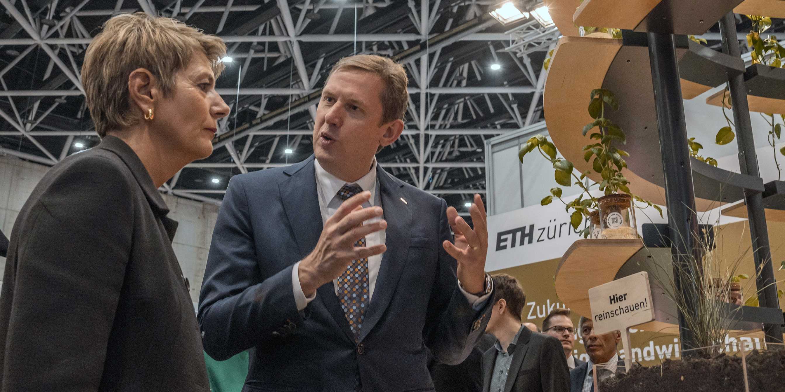 Christian Wolfrum stands to the right of Karin Keller-Sutter and explains the ETH Zurich stand to her