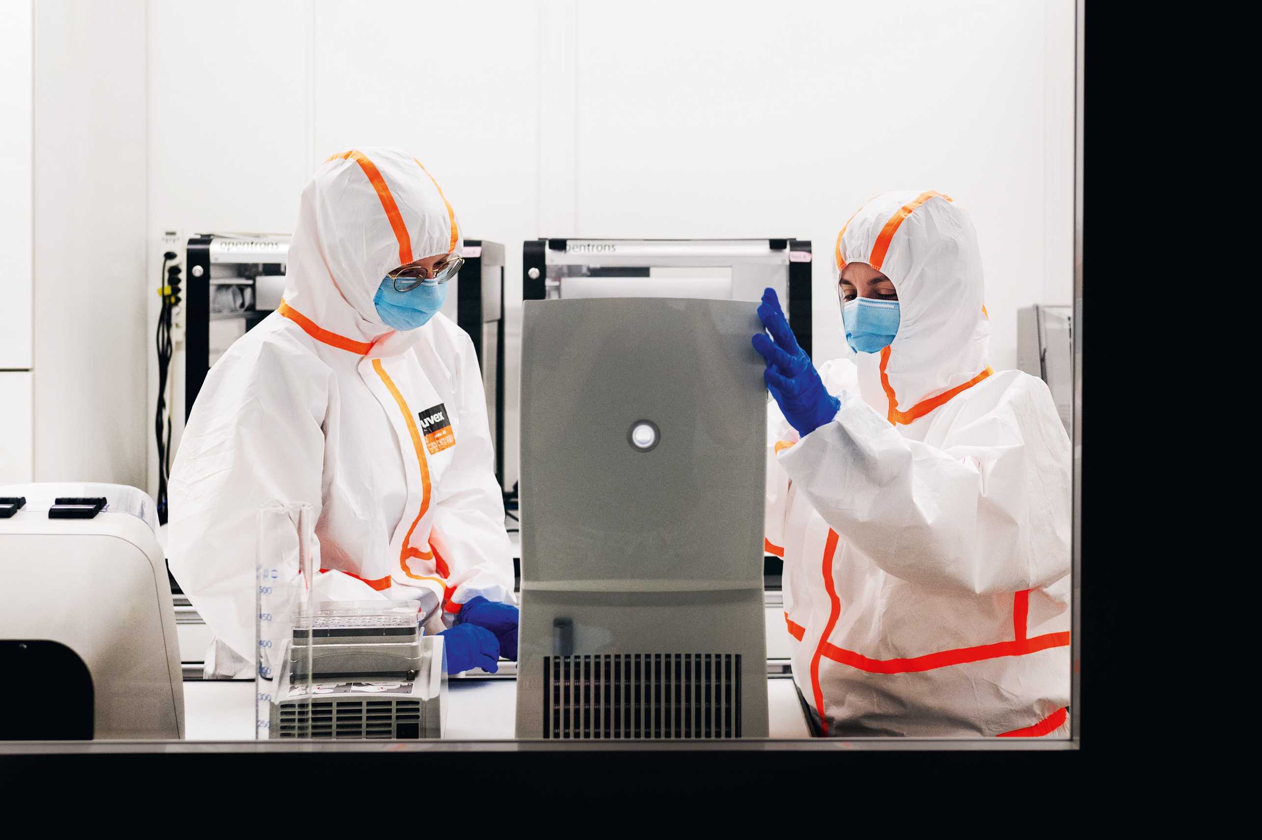 Enlarged view: Two people in protective suits are working on the samples.
