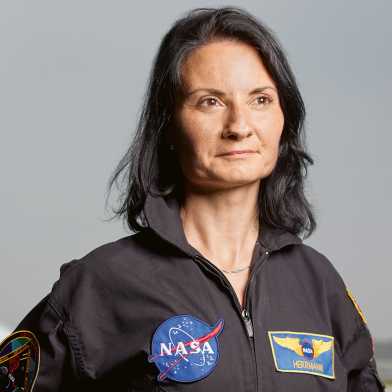 Sandra Herrmann dressed in a Nasa jumpsuit and standing proudly in front of a jet