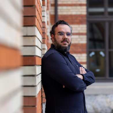 Digital epidemiologist Onicio Batista Leal Neto standing in front of an ETH building with his arms folded.