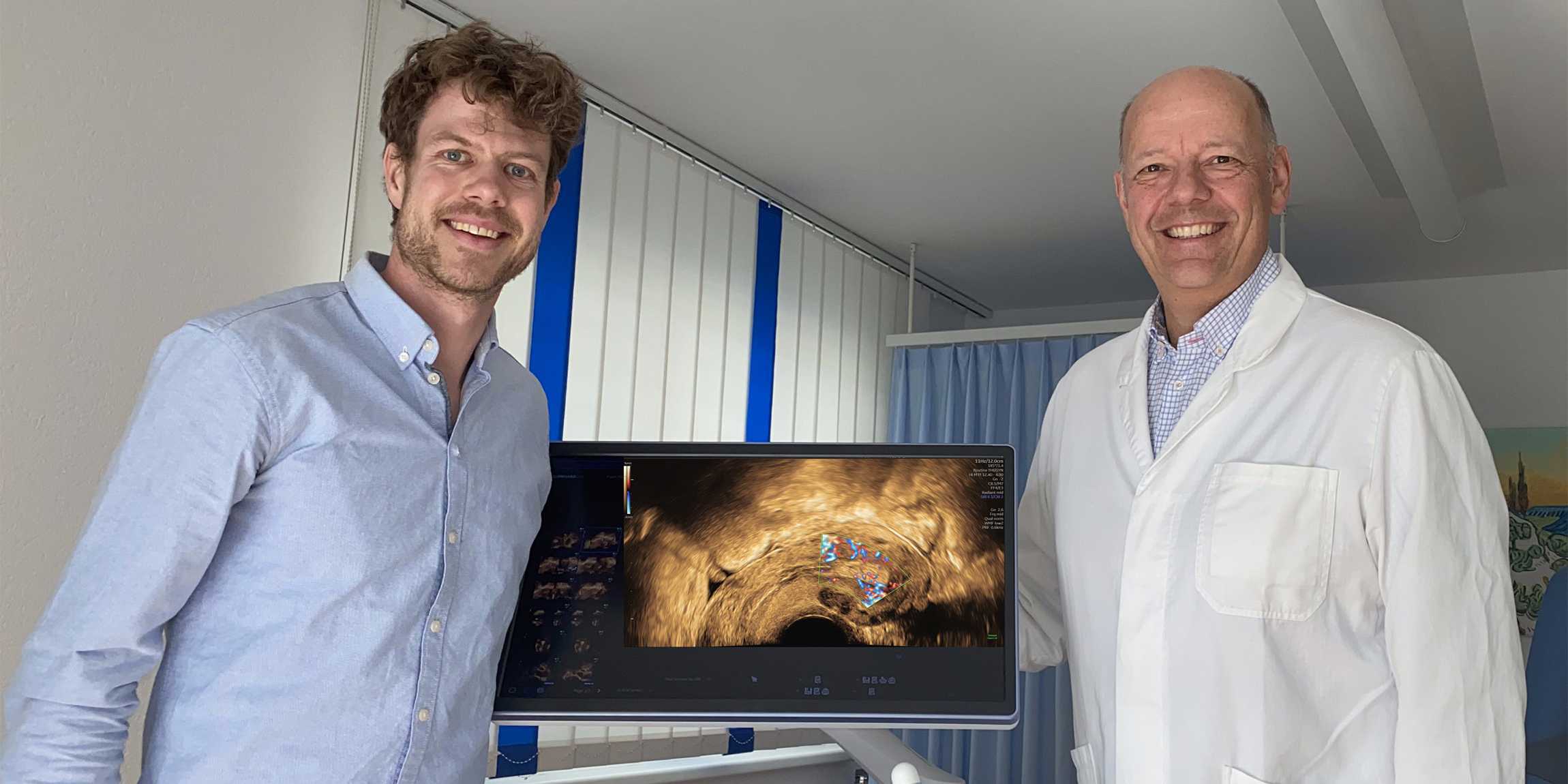 ETH researcher Fabian Laumer (left) and gynecologist Michael Bajka stand next to a screen showing an ultrasound image.