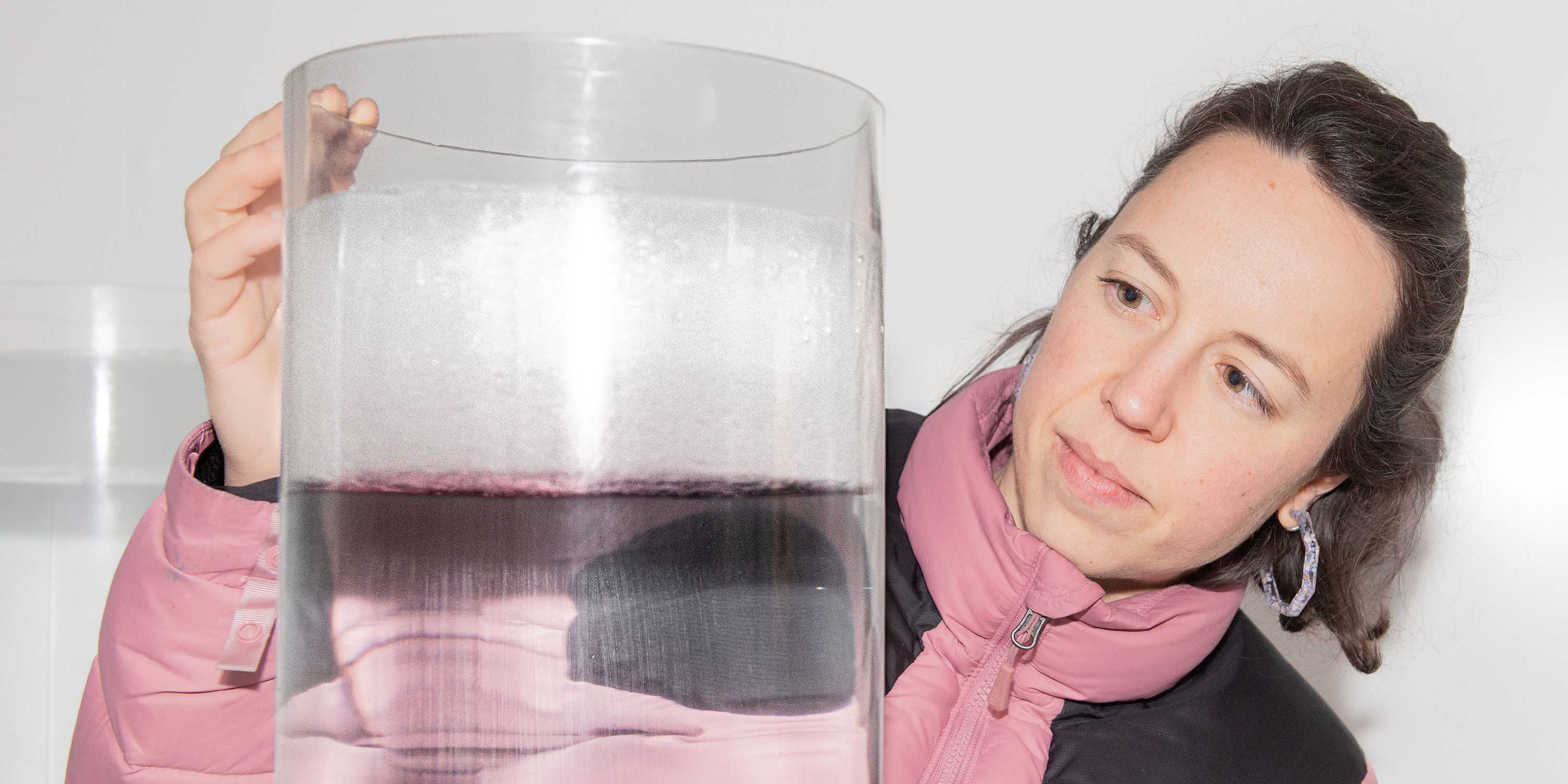 Woman is looking at a huge tube with liquid and ice