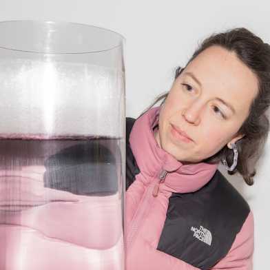 Woman is looking at a huge tube with liquid and ice