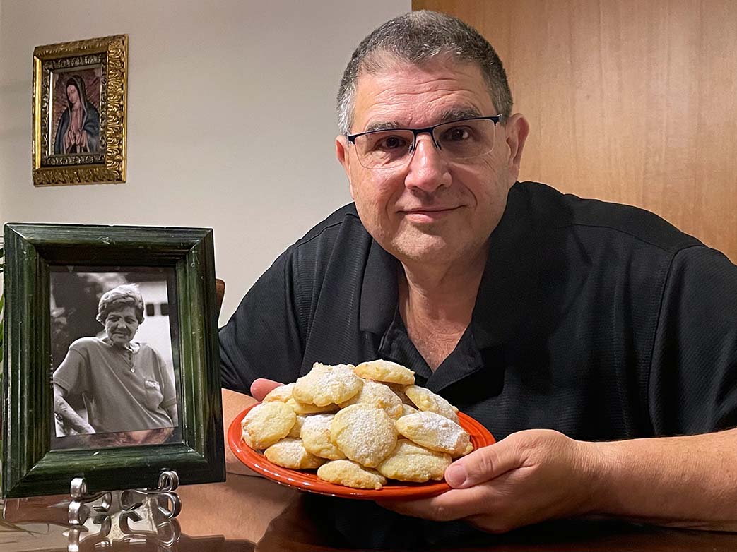 Nicholas Cardo with a picture of his grandmother, Evelyn and a plate full of cookies