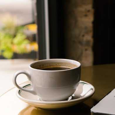 Bild eines Laptops mit einer Kaffeetasse daneben